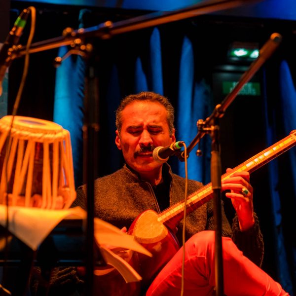 Scène de l’événement “Culture et poésie” à Strasbourg organisé par Strass’Iran : artistes et participants lors d’une lecture de poésie et performance musicale.